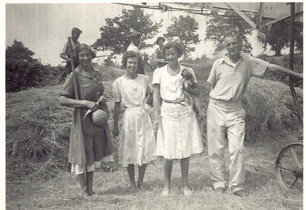 Dorothy Crowther-Smith (far L) and Gervas Hughes (far R) baling hay at her farm during his recovery from polio at Bordon in H